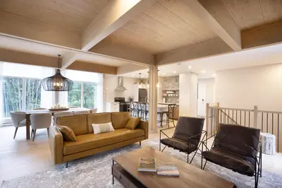 a living room with a couch and a table at Chalet Mid-Century - Lakeside Joseph - Le Charlo in Saint-Pierre-Baptiste