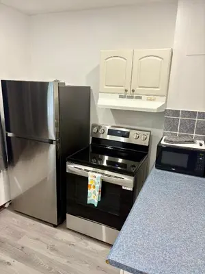 a kitchen with a stainless steel stove and refrigerator at Shope & Stay Central 7 in Montréal