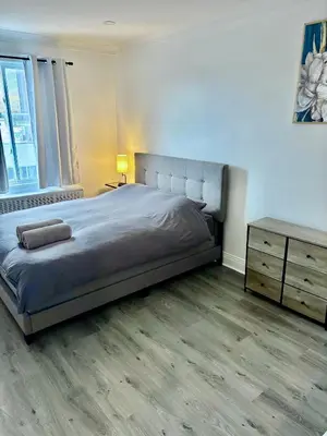 a bedroom with a bed and a wooden floor at Shope & Stay Central 7 in Montréal