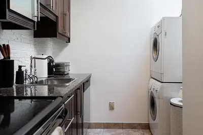a kitchen with a sink and a washer and dryer at Sunny Open Loft in Montréal