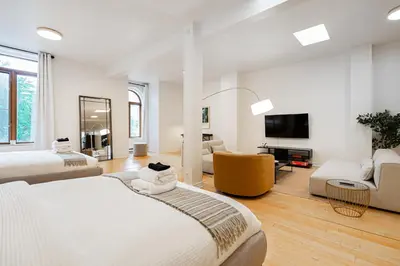 a large white room with a bed and a tv at Sunny Open Loft in Montréal