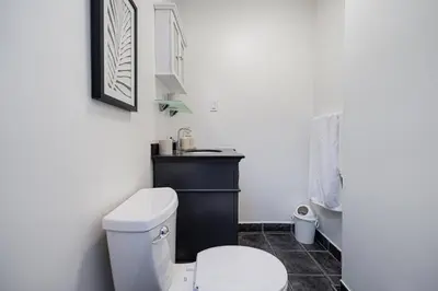 a bathroom with a white toilet and a sink at Sunny Open Loft in Montréal