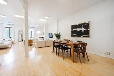 a dining room and living room with a table and chairs at Sunny Open Loft in Montréal