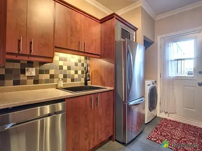 a kitchen with wooden cabinets and a stainless steel refrigerator at 80m2 Vieux-Montreal, CHUM & metro 1 min, Parking in Montréal