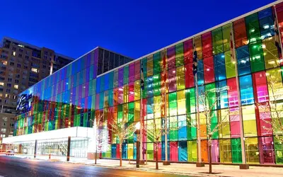 a large glass building with a colorful facade at night at 80m2 Vieux-Montreal, CHUM & metro 1 min, Parking in Montréal