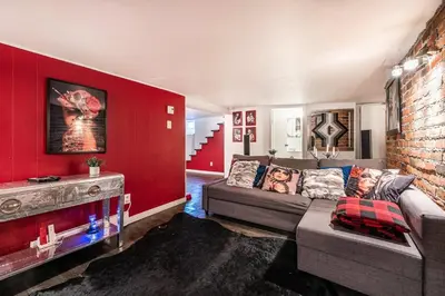 a living room with a couch and a red wall at Cohabs Montréal in Montréal