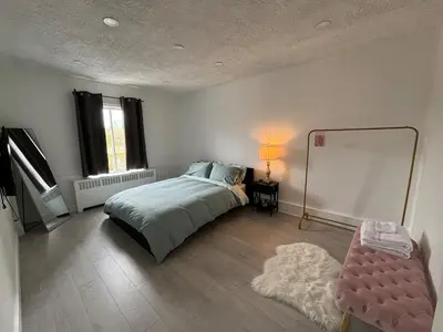 a bedroom with a bed and a mirror and a chair at Shop & Stay Central 8 in Montréal