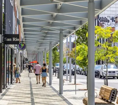 a group of people walking down a sidewalk at Shop & Stay Central 6 in Montréal
