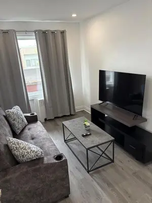 a living room with a couch and a flat screen tv at Shop & Stay Central 6 in Montréal