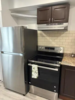 a kitchen with a stainless steel refrigerator and a stove at Shop & Stay Central 6 in Montréal