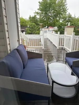 a porch with a blue couch and a table at Shop & Stay Central 6 in Montréal