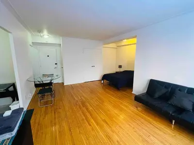 a living room with a black couch and a table at Modern City Apartment Living in the Golden Square Mile in Montréal