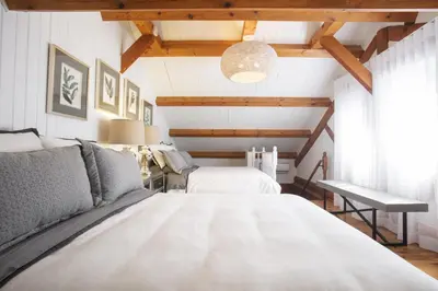 a bedroom with two beds and a table at Log cabin - Lakeside - Le Oly in Saint Romain