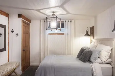 a white bedroom with a bed and a window at Log cabin - Lakeside - Le Oly in Saint Romain