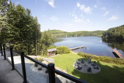 a view of a lake from a balcony at Log cabin - Lakeside - Le Oly in Saint Romain