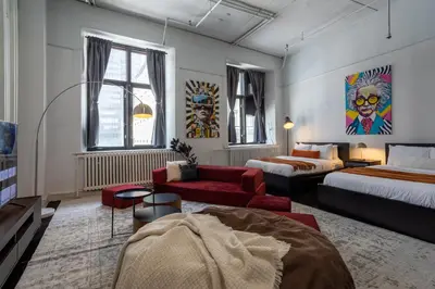 a hotel room with two beds and a couch at 4 Stylish Lofts in Old Montreal in Montréal