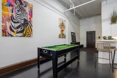 a room with a pool table and some paintings at 4 Stylish Lofts in Old Montreal in Montréal