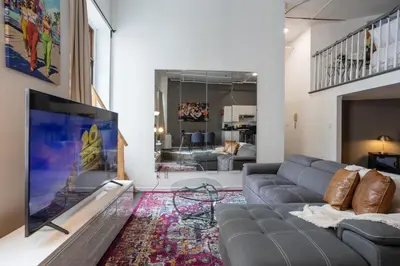 a living room with a couch and a flat screen tv at 4 Stylish Lofts in Old Montreal in Montréal