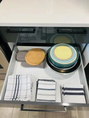 a drawer with plates and towels in a cabinet at Great Gaston in Longueuil