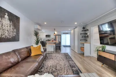 a living room with a brown leather couch and a kitchen at Great Gaston in Longueuil