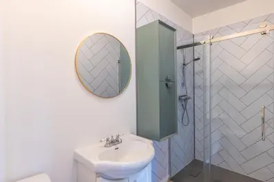a white bathroom with a sink and a mirror at Chez Flo in Trois-Rivières
