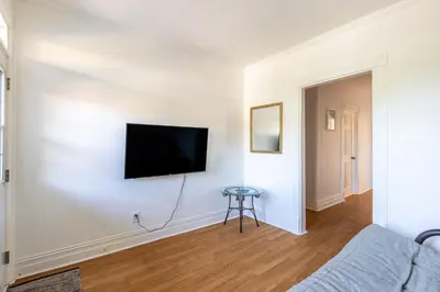a living room with a flat screen tv on a white wall at Chez Flo in Trois-Rivières