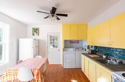 a kitchen with yellow cabinets and a white refrigerator at Chez Flo in Trois-Rivières