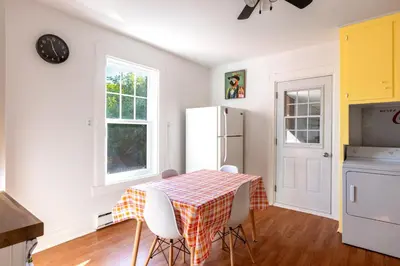 a kitchen with a table with chairs and a refrigerator at Chez Flo in Trois-Rivières