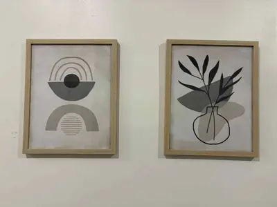 two framed pictures on a wall with a plant at Spacious apartment in dowtown Montreal in Montréal