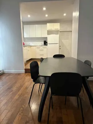 a table and chairs in a room with a kitchen at Spacious apartment in dowtown Montreal in Montréal