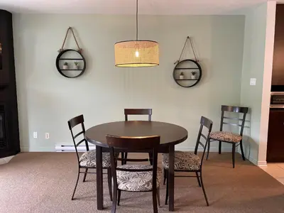 a dining room with a table and chairs at Superbe ski-in ski-out condo in Bromont