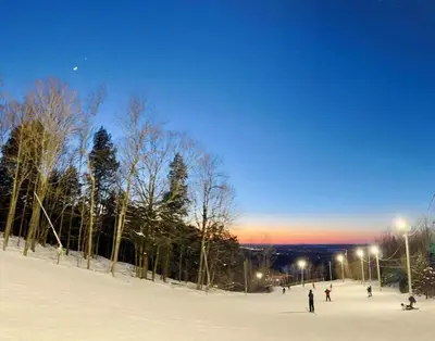 a group of people skiing on a snow covered slope at Superbe ski-in ski-out condo in Bromont