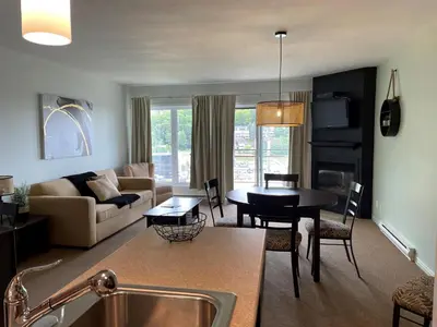 a living room with a couch and a table at Superbe ski-in ski-out condo in Bromont
