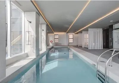 a large swimming pool with blue water in a building at TDC2 - 28th floor - 2 bd, 2 bth in Montréal