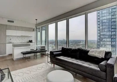 a living room with a couch and large windows at TDC2 - 28th floor - 2 bd, 2 bth in Montréal