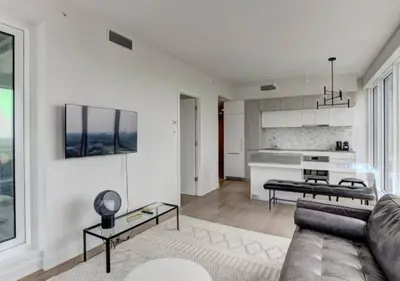 a living room with a couch and a kitchen at TDC2 - 28th floor - 2 bd, 2 bth in Montréal