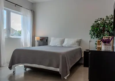 a bedroom with a large bed and a window at Modern Apartment - Home Theater and Premium Kitchen in Terrebonne