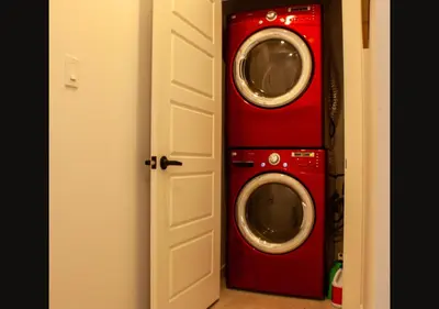 a washer and dryer in a red room at Modern Apartment - Home Theater and Premium Kitchen in Terrebonne