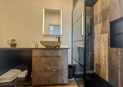 a bathroom with a sink and a shower with a mirror at Modern Apartment - Home Theater and Premium Kitchen in Terrebonne