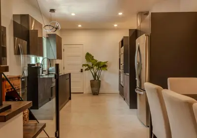 a kitchen with black cabinets and a potted plant at Modern Apartment - Home Theater and Premium Kitchen in Terrebonne