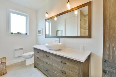 a bathroom with a sink and a mirror at House on a beautiful maple grove in Valcourt