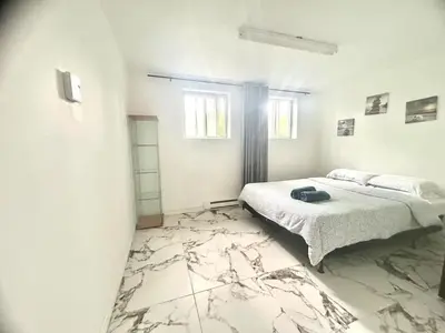 a bedroom with a bed and a marble floor at Downtown 2B Basement Unit in Montréal