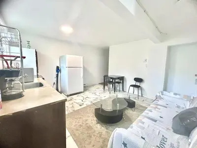 a kitchen with a couch and a table and a refrigerator at Downtown 2B Basement Unit in Montréal