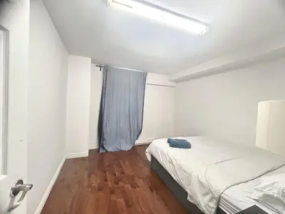a white room with a bed and a window at Downtown 2B Basement Unit in Montréal