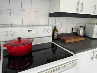 a red pot sitting on top of a stove in a kitchen at Large Sunny 3 bedroom home in great neighbourhood in Montréal
