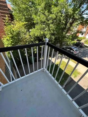a balcony with a white railing and a street at Large Sunny 3 bedroom home in great neighbourhood in Montréal