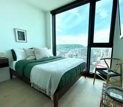 a bedroom with a bed and a large window at Luxurious condo dowtown Montréal in Montréal