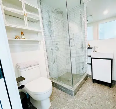a bathroom with a toilet and a glass shower at Luxurious condo dowtown Montréal in Montréal