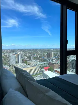 a bedroom with a view of a city at Luxurious condo dowtown Montréal in Montréal