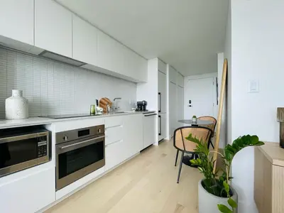 a kitchen with white cabinets and a table with a plant at Luxurious condo dowtown Montréal in Montréal